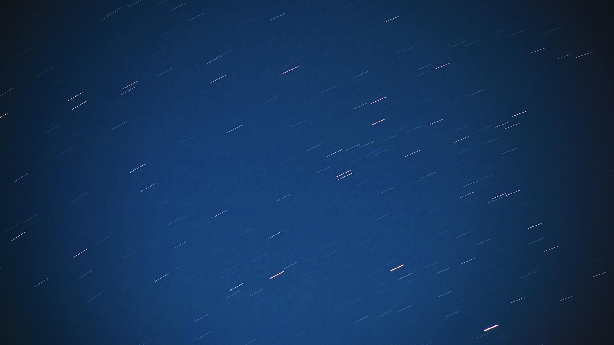 Captivating long exposure of star trails against a deep blue night sky, highlighting cosmic motion.
